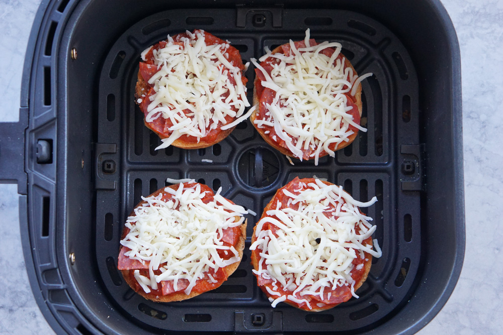 homemade bagel bites in the air fryer basket ready to cook.