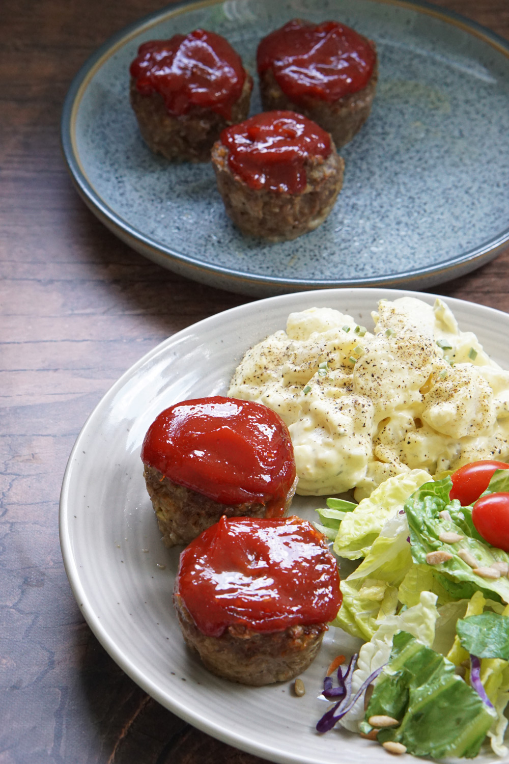 Meatloaf bites on a plate with potato salad and green salad, air fryer meatloaf bites