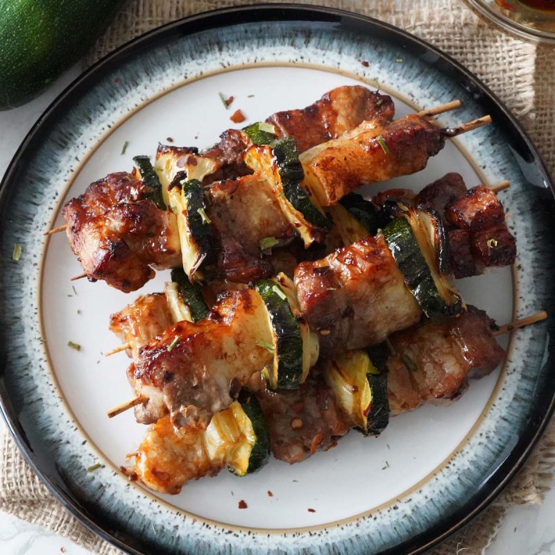 A plate of pork belly skewers
