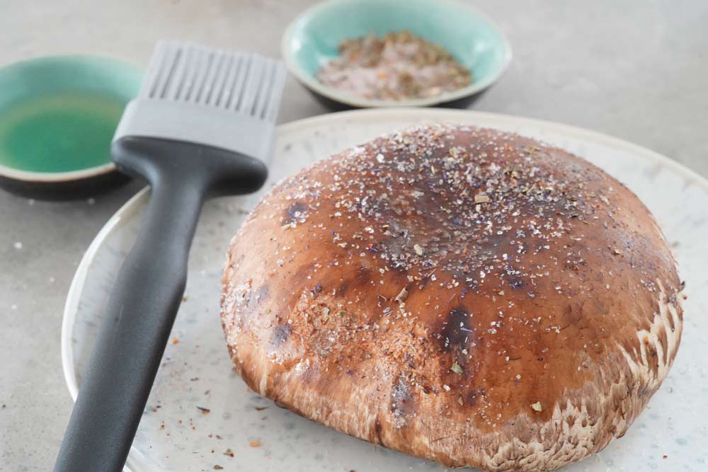 Seasoning an uncooked Portobello mushroom