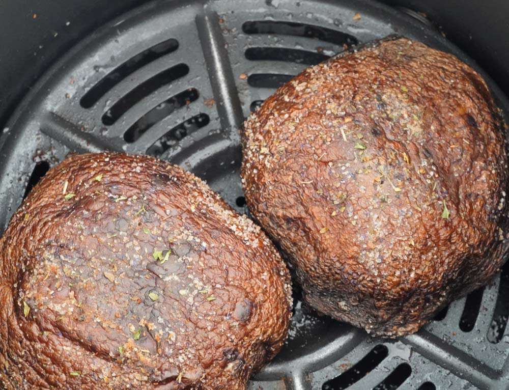 Two Portobello mushrooms in the air fryer basket