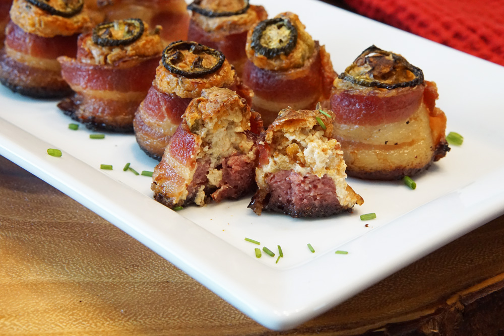Bacon wrapped sausage with cream cheese filling cut in half